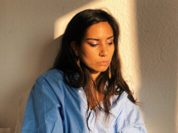 A portrait of poet Aria Aber in sunlight