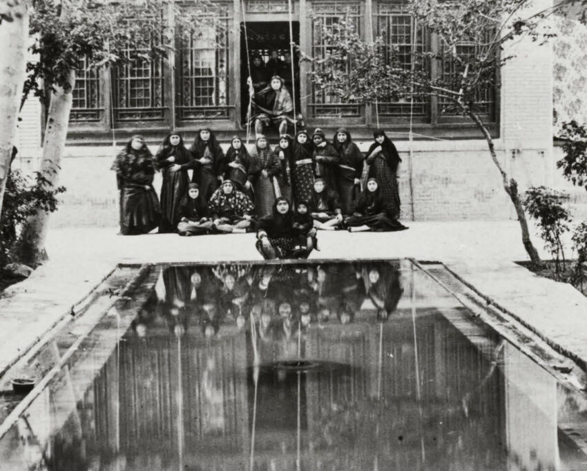 A group of people overlook a mirrored pool