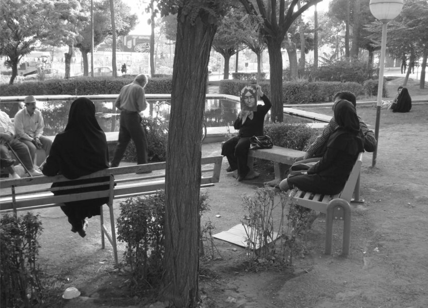 A group of people sit on chairs in a park