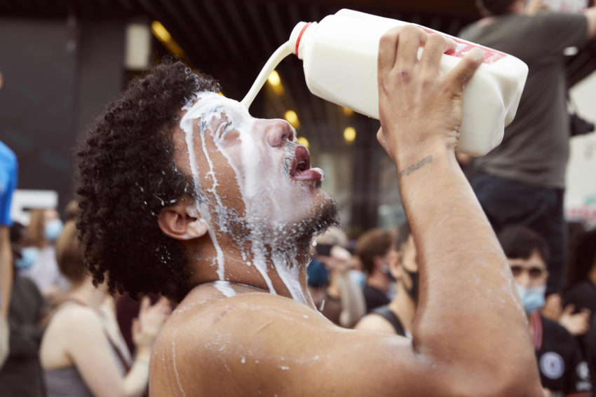 A man pouring milk in his eyes