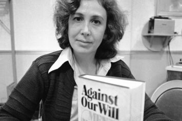 Black-and-white photo of Susan Brownmiller with a copy of her book Against Our Will